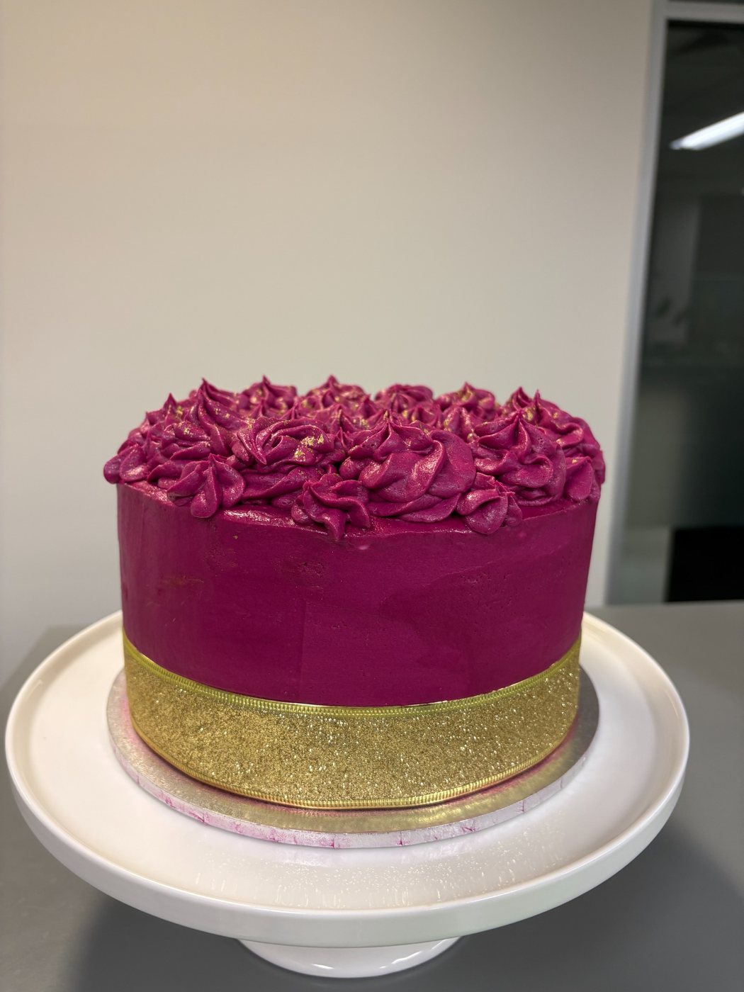 Magenta buttercream cake with gold ribbon