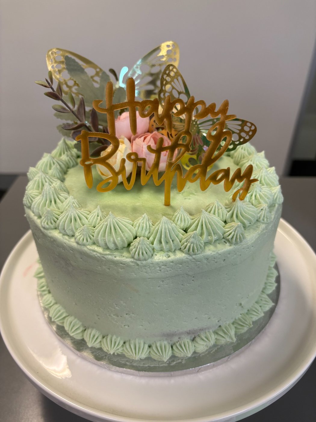 Mint birthday cake with flowers and gold butterflies
